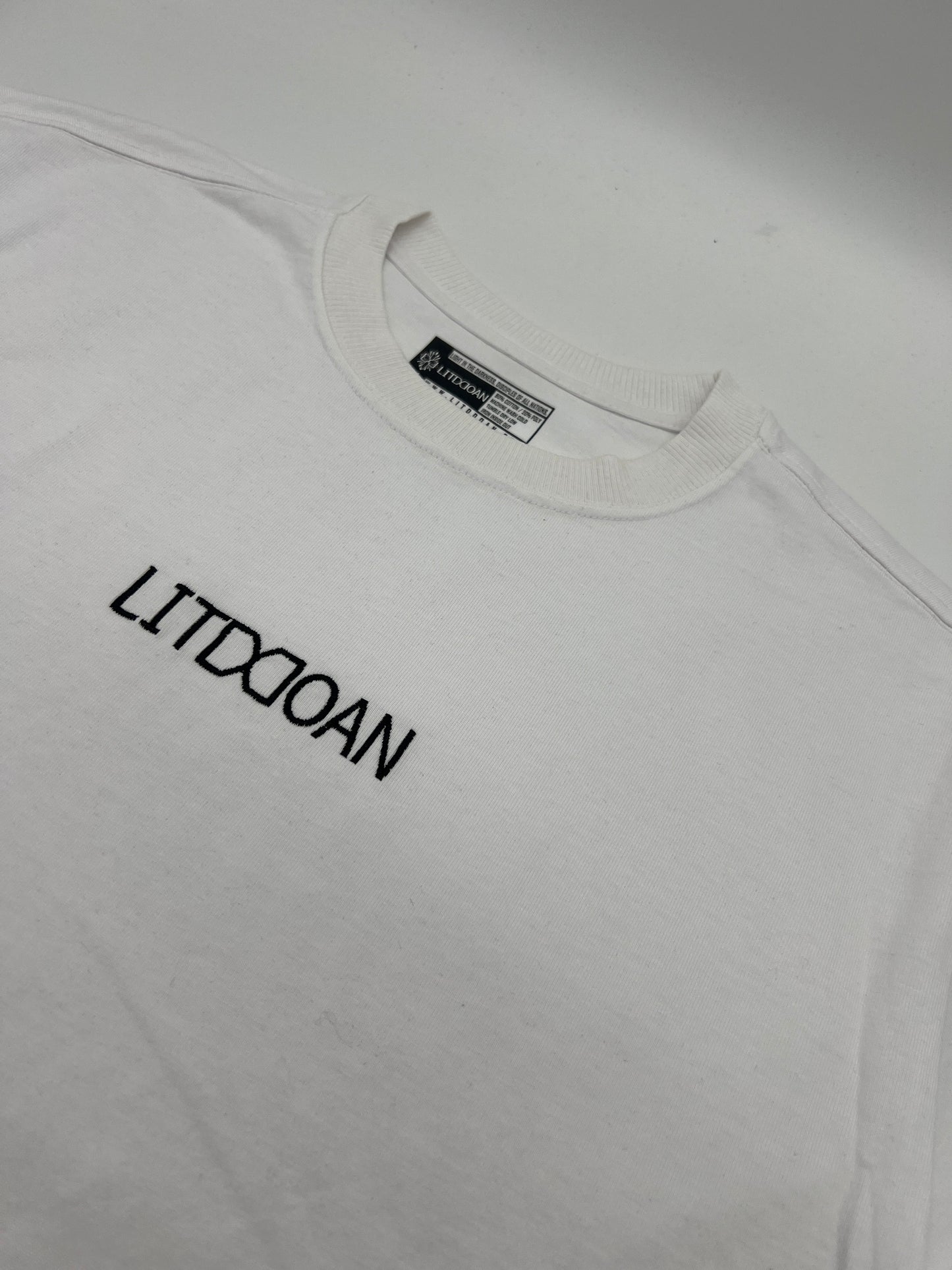 White t-shirt with black text on a plain background