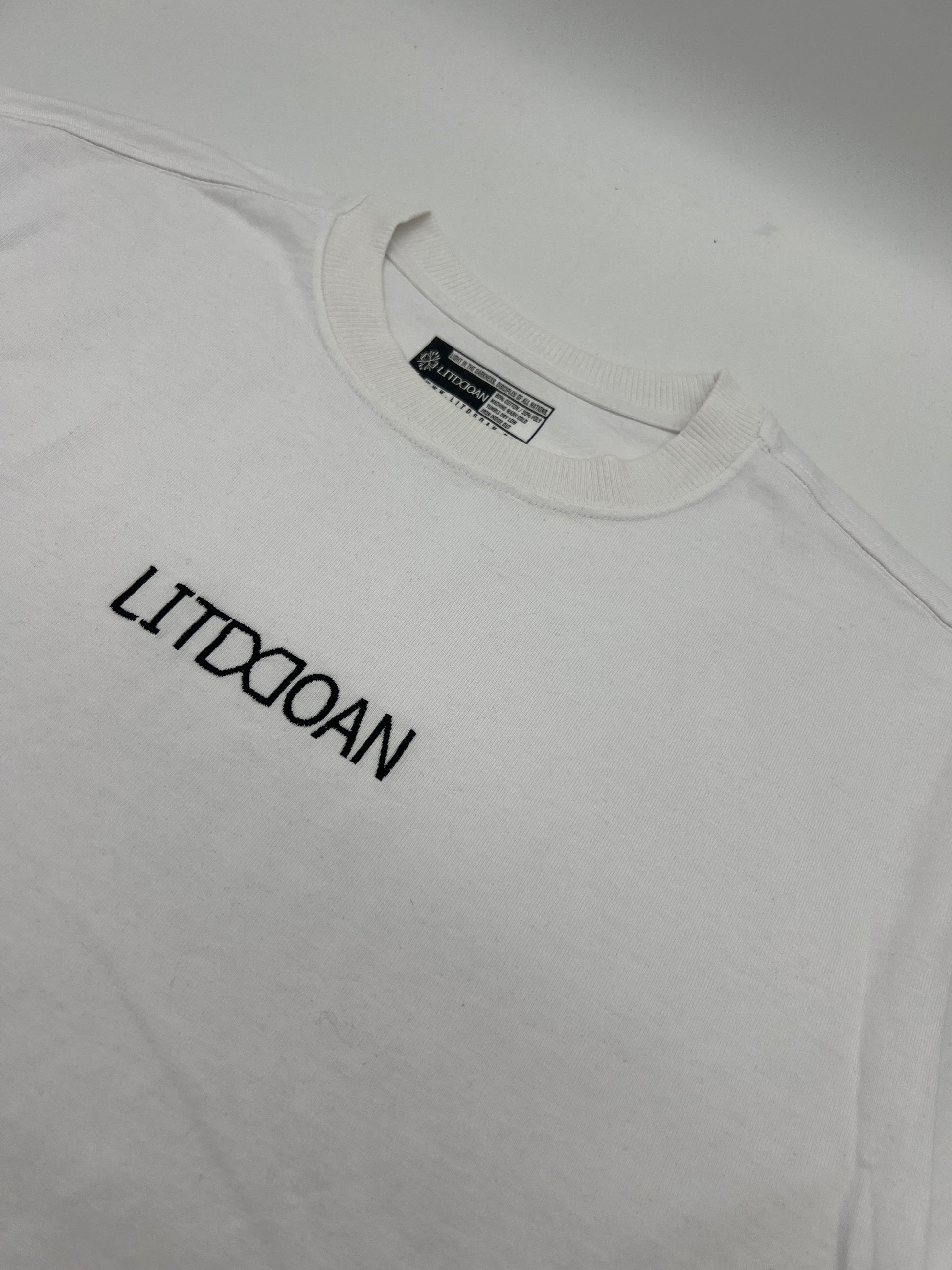 White t-shirt with black text on a plain background